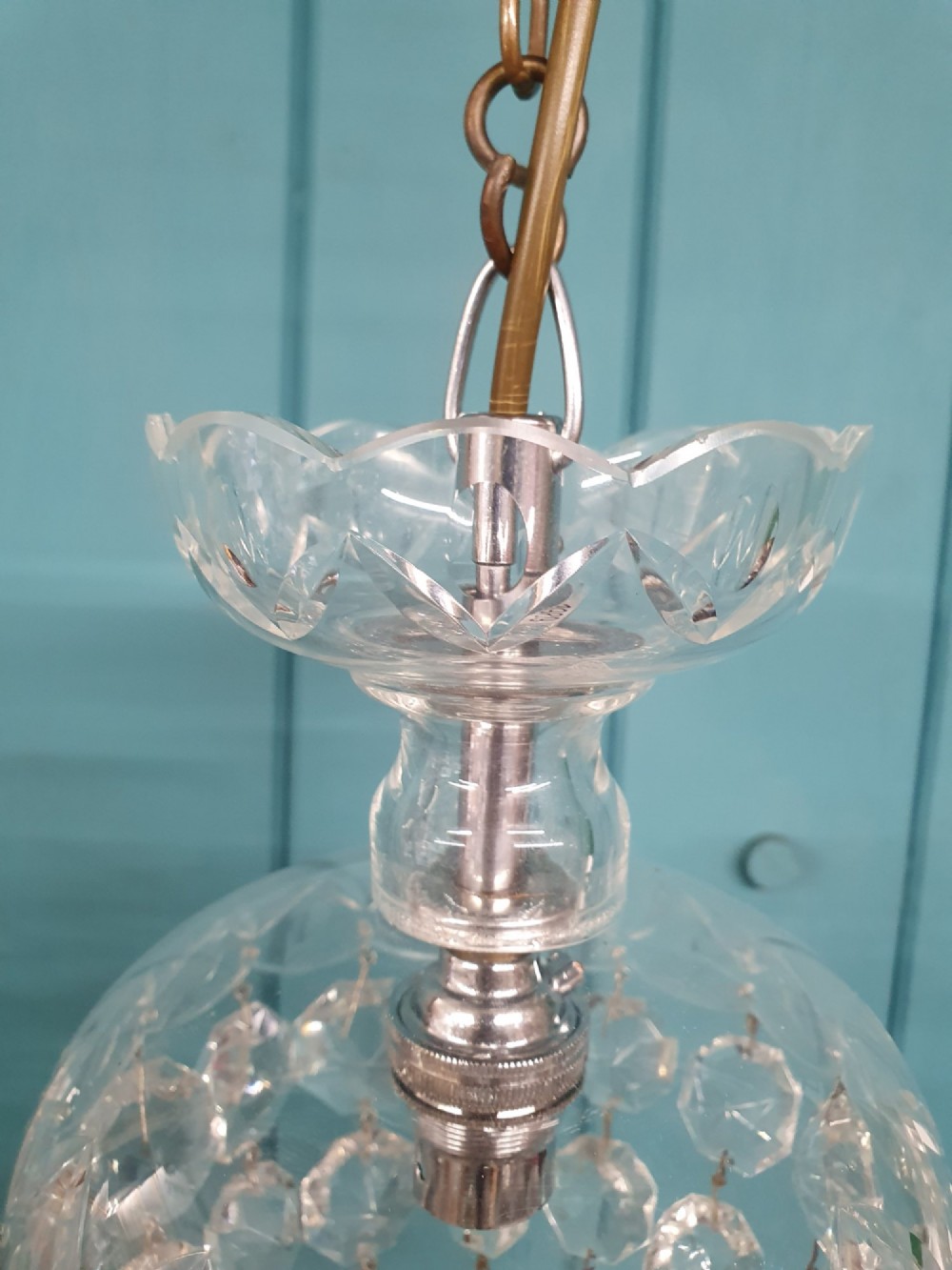 An early twentieth-century clear glass dome top chandelier featuring faceted crystal drops and a suspended hanging brass chain. View VII