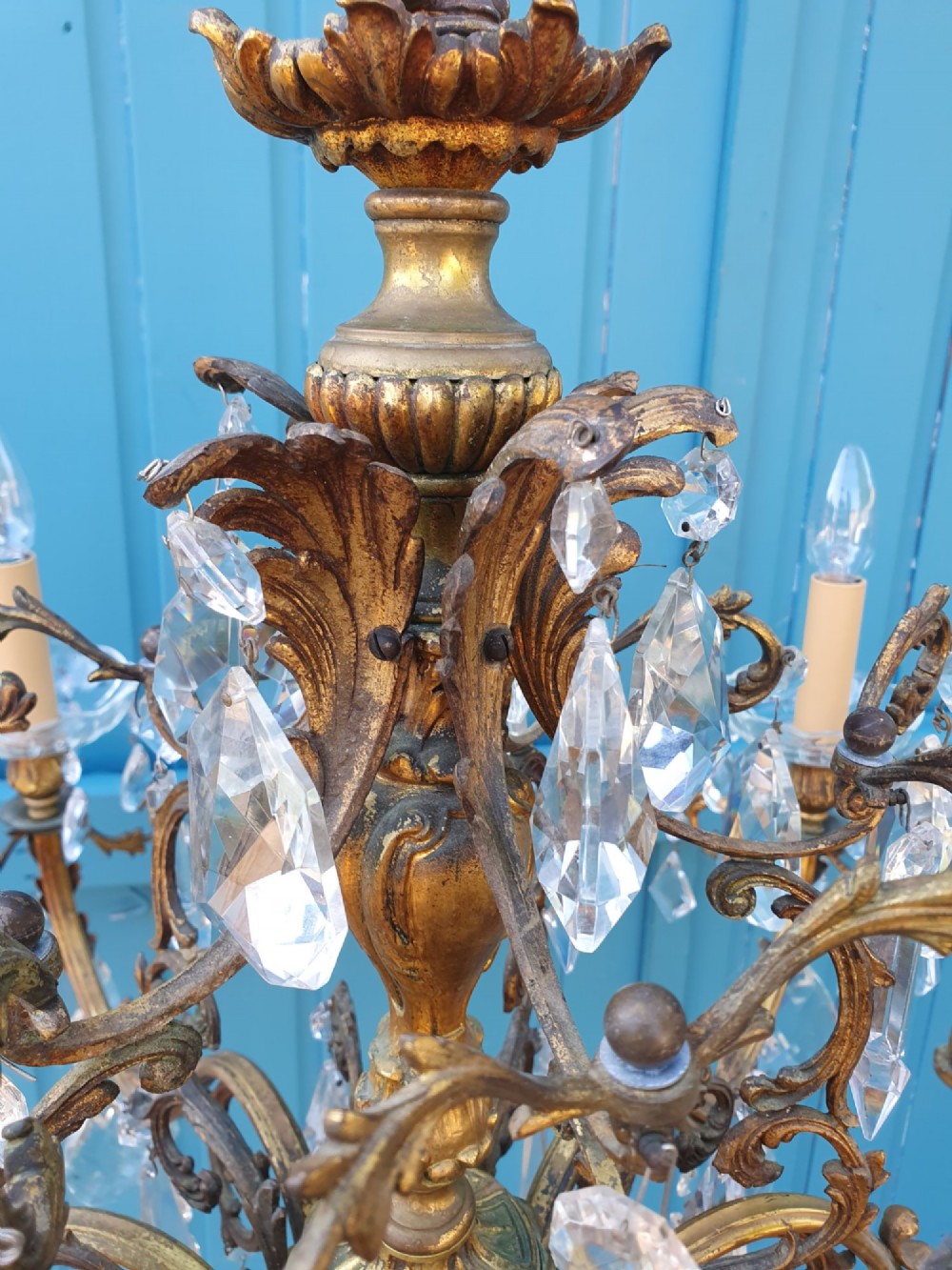 A ten-arm gilt brass chandelier with scrolling arms and suspended clear crystal drops. View II