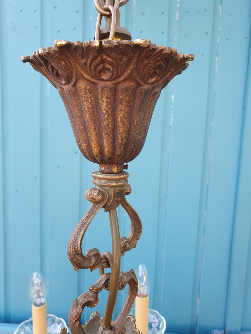 A ten-arm gilt brass chandelier with scrolling arms and suspended clear crystal drops. View VI