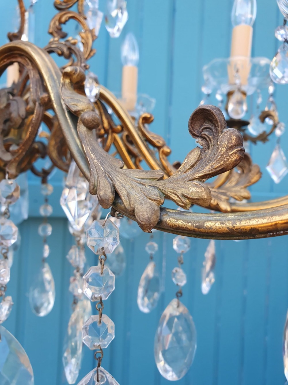 A ten-arm gilt brass chandelier with scrolling arms and suspended clear crystal drops. View IX