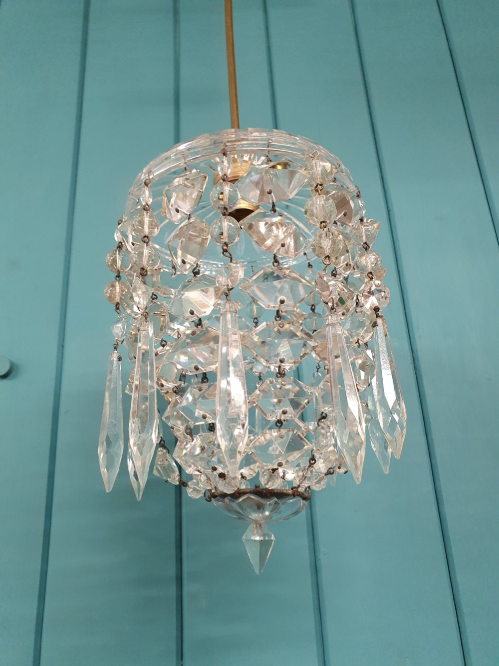 A small antique cut glass dome chandelier with suspended faceted crystal droplets mounted on a central brass stem. View IV