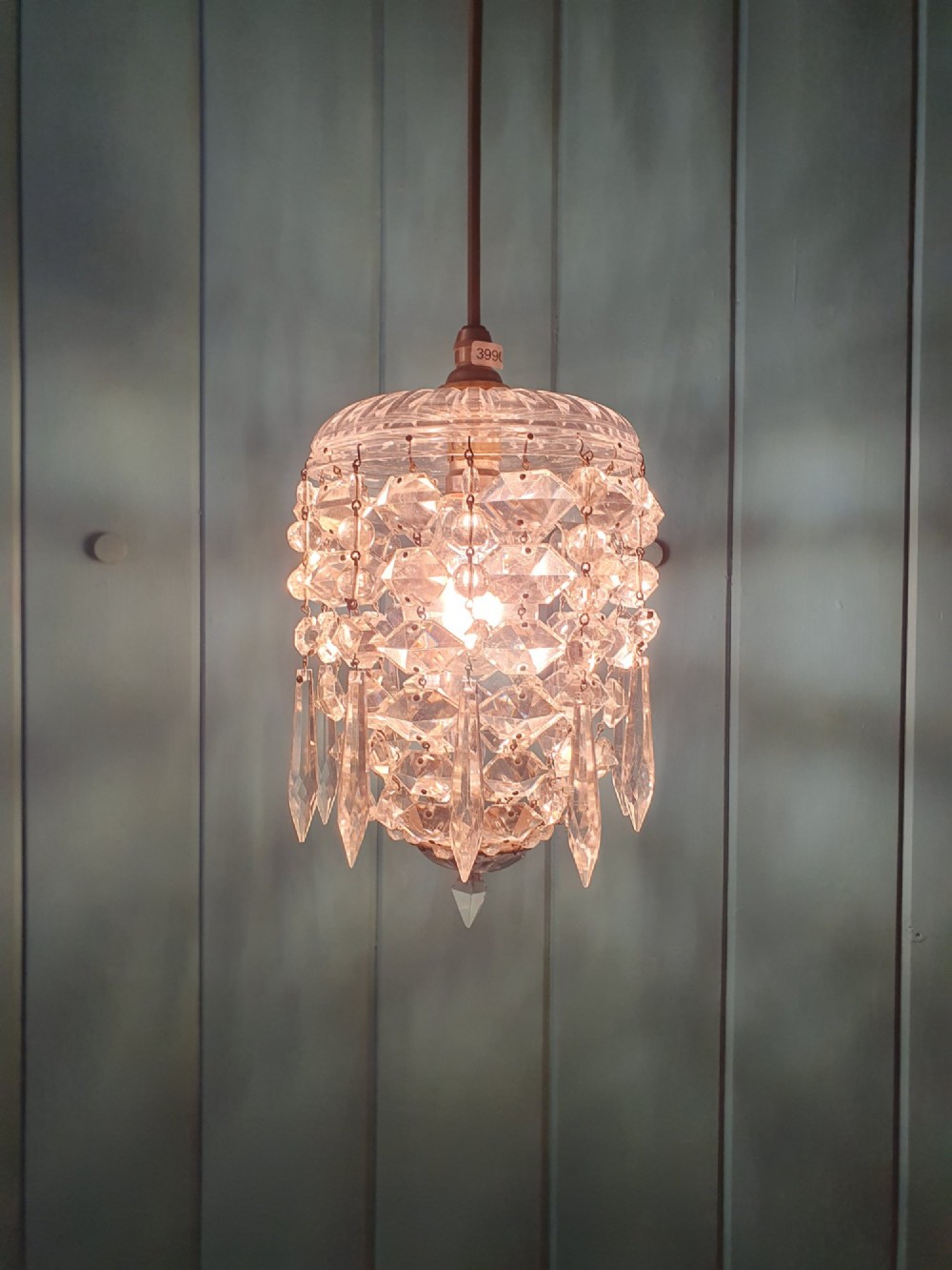 A small antique cut glass dome chandelier with suspended faceted crystal droplets mounted on a central brass stem. View V