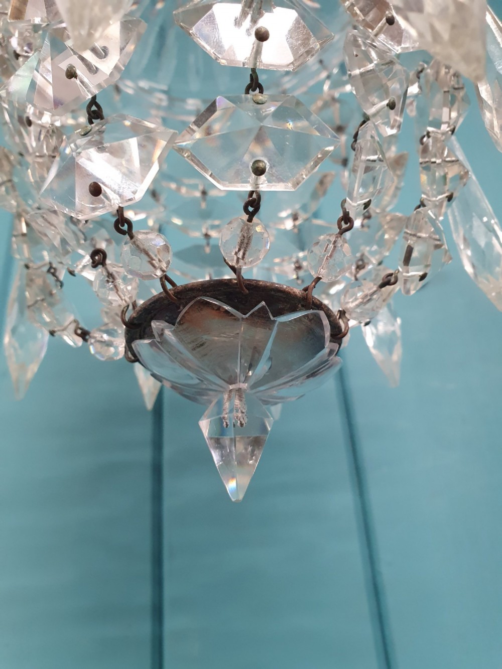 A small antique cut glass dome chandelier with suspended faceted crystal droplets mounted on a central brass stem. View VI