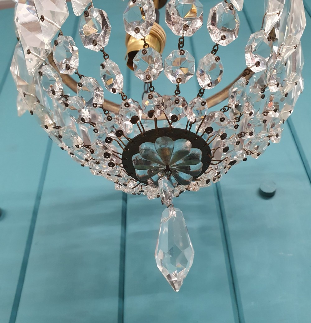 An early twentieth-century small bag-style chandelier featuring cut crystal coffin prisms, a decorative brass upper rim with leaf detail, and a suspension chain. View III