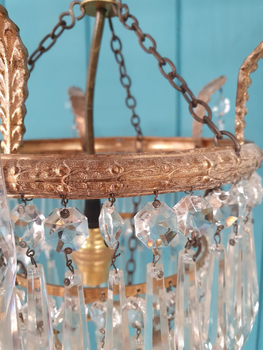 A small three-tier brass pendant chandelier with cascading clear glass icicle drops suspended from a brass chain. View II