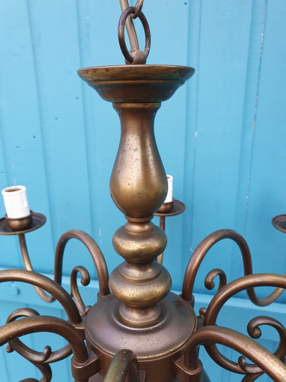 A pair of antique Dutch Flemish brass chandeliers featuring multi-arm S-scroll branches and central baluster stems with hanging chains. View IV