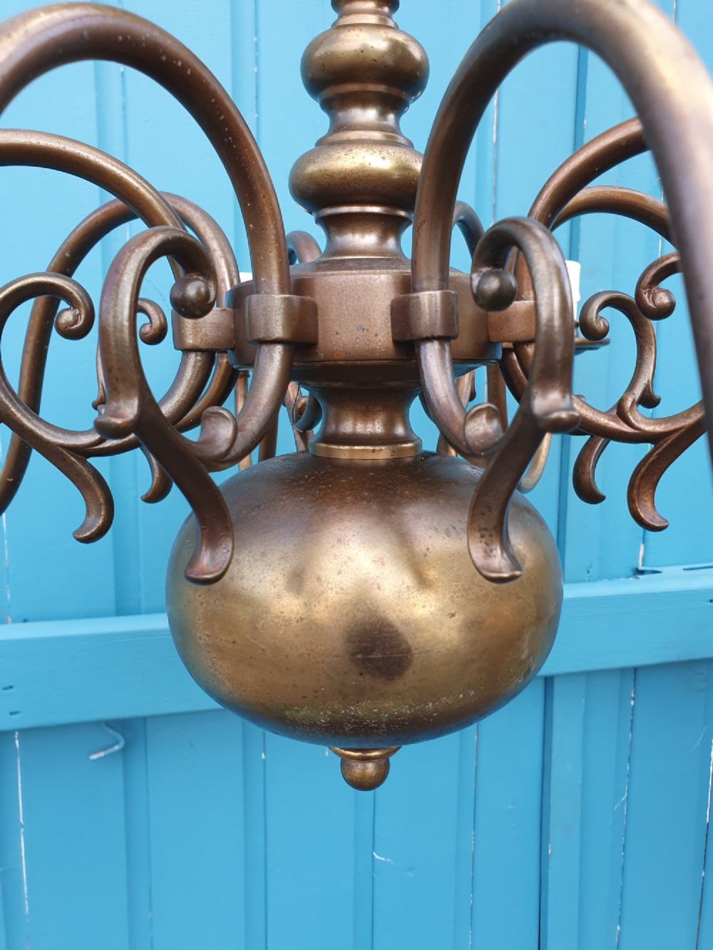 A pair of antique Dutch Flemish brass chandeliers featuring multi-arm S-scroll branches and central baluster stems with hanging chains. View V