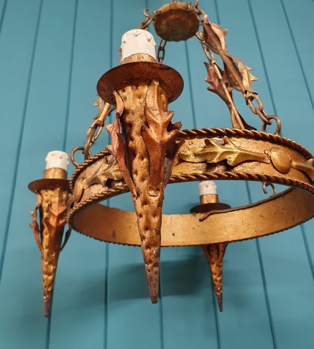 A late 19th-century French gilded metal coronet chandelier featuring a circular band adorned with leaf motifs and four candle-style light sockets suspended by chains. View IV