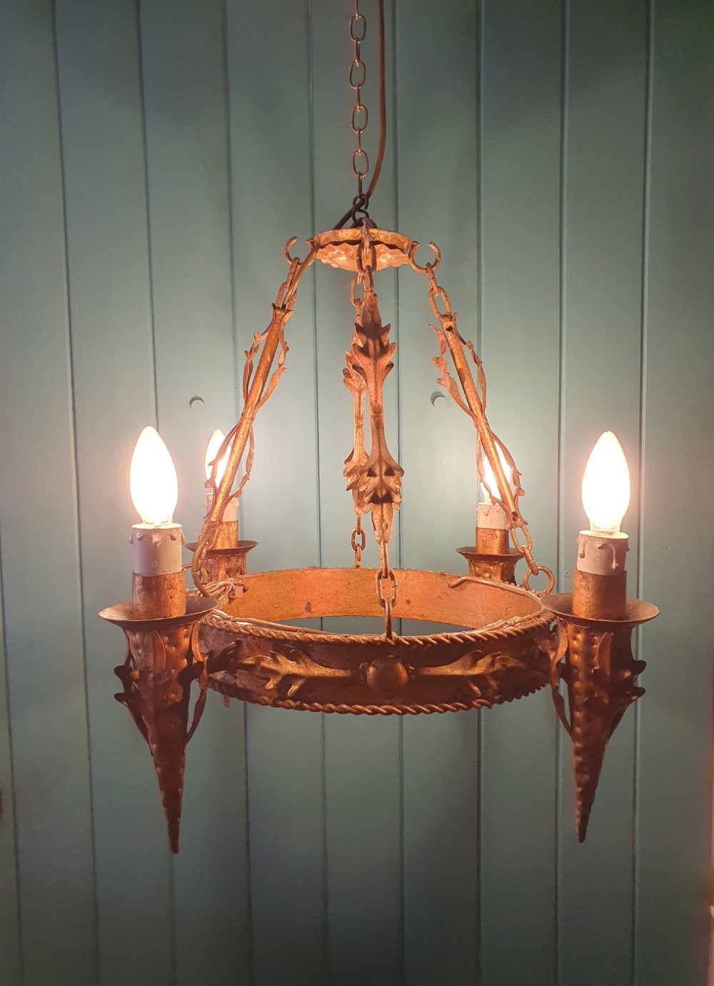A late 19th-century French gilded metal coronet chandelier featuring a circular band adorned with leaf motifs and four candle-style light sockets suspended by chains. View VI