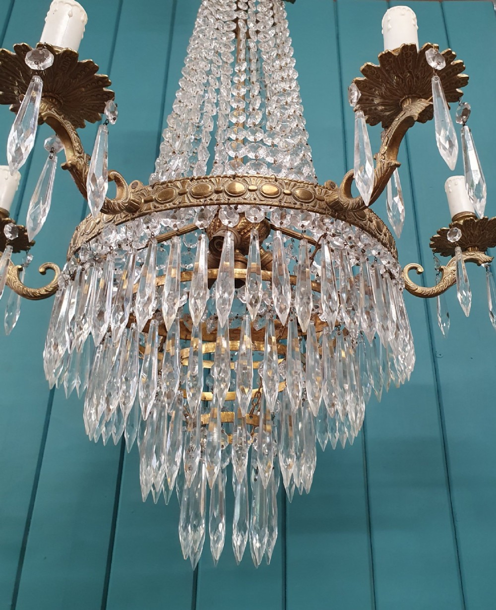 A six-arm brass tent chandelier decorated with crystal beads, drop pendants, and a leaf corona at the top. View III