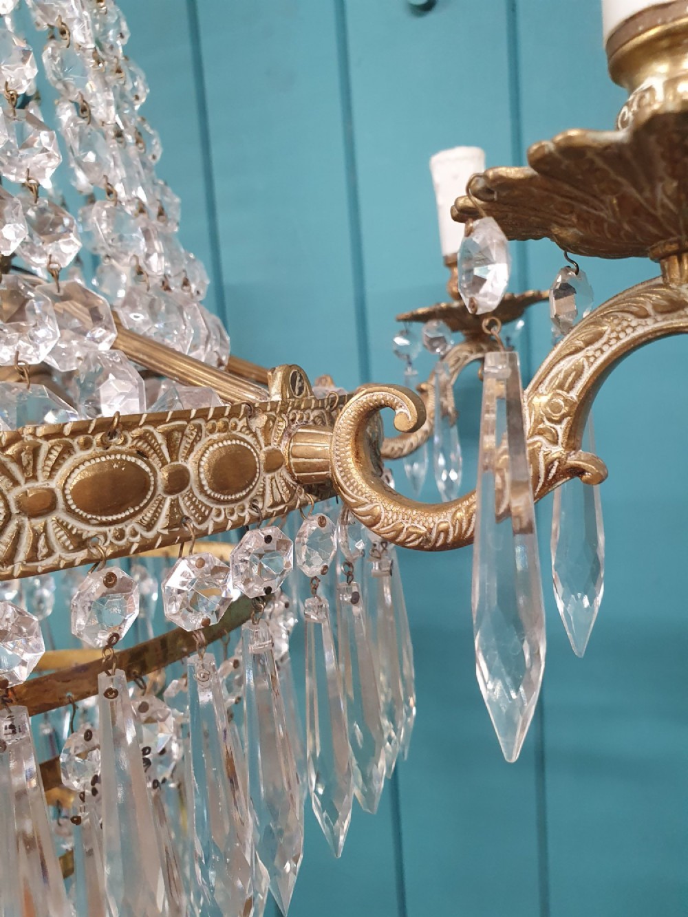 A six-arm brass tent chandelier decorated with crystal beads, drop pendants, and a leaf corona at the top. View IV