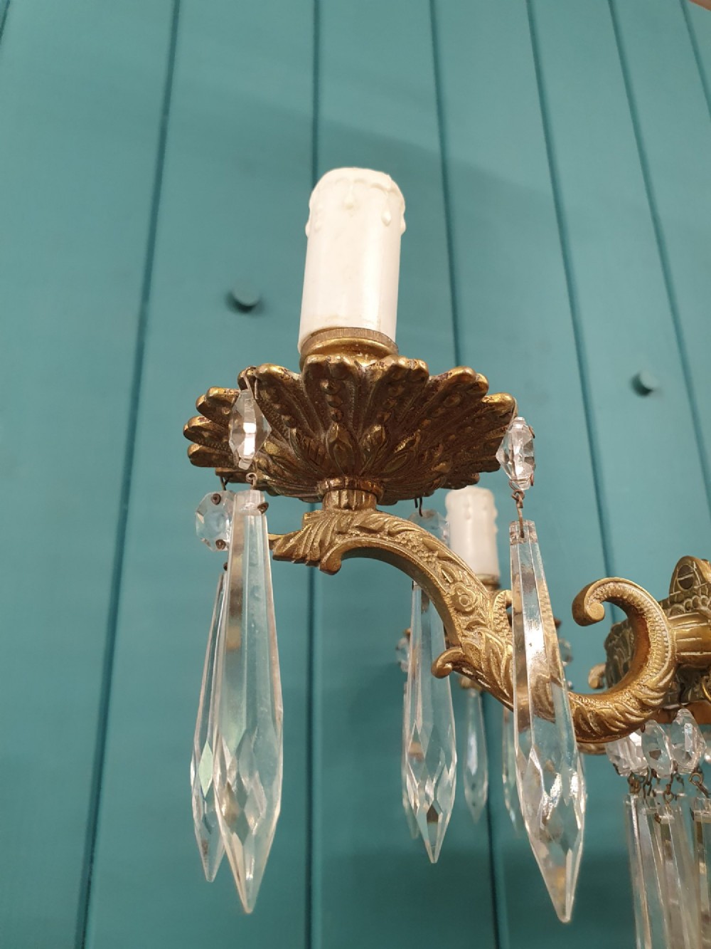 A six-arm brass tent chandelier decorated with crystal beads, drop pendants, and a leaf corona at the top. View VI