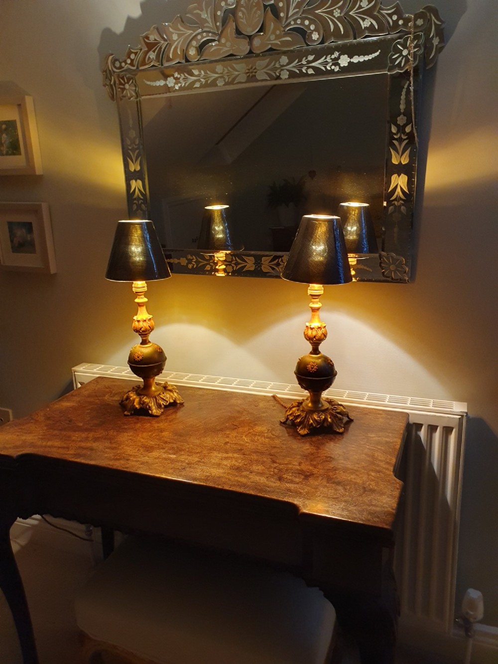 A pair of early 20th-century gilt brass table lamps featuring flared acanthus leaf bases, dark spherical central sections with gold floral mounts, and turned upper columns. View VIII