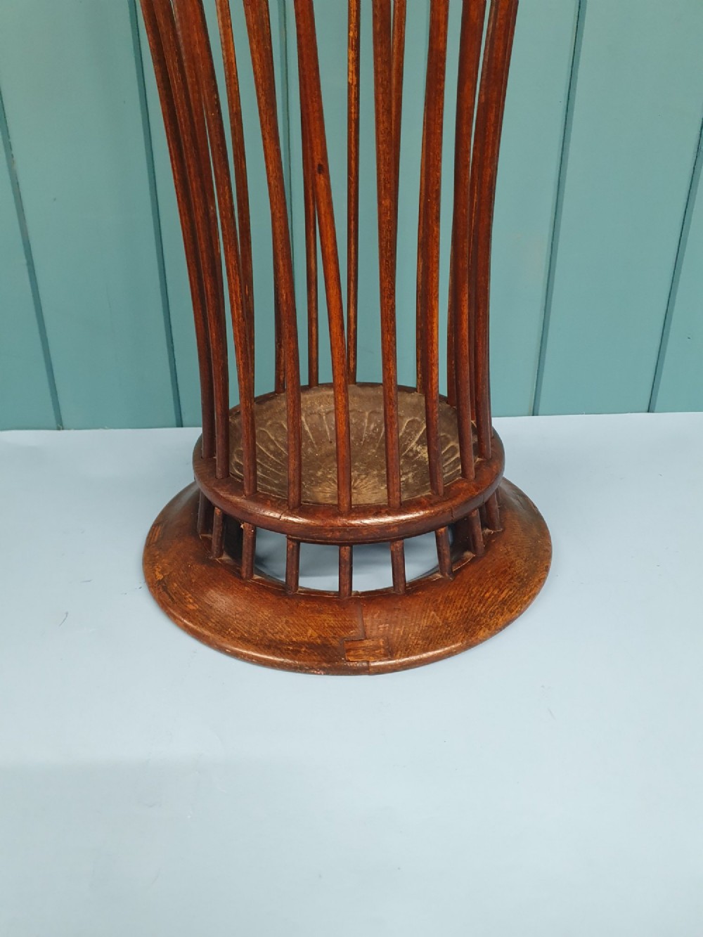 An early 20th-century oak stick stand featuring a flared, circular slatted framework tapering at the centre with an integrated metal drip tray at the circular base. View VIII