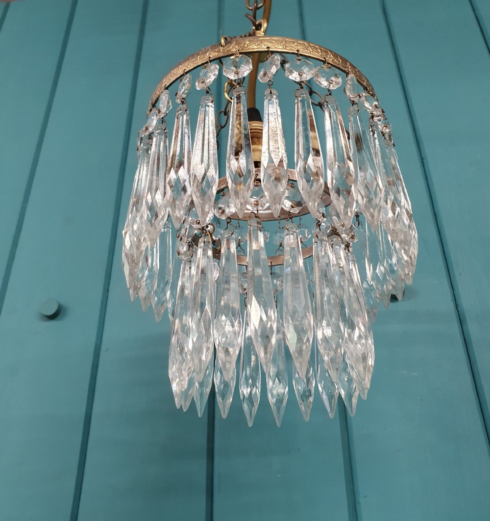 An early twentieth-century small brass ceiling light featuring suspended tiers of pointed cut glass crystal drops hanging from an ornate metal rim. View VI
