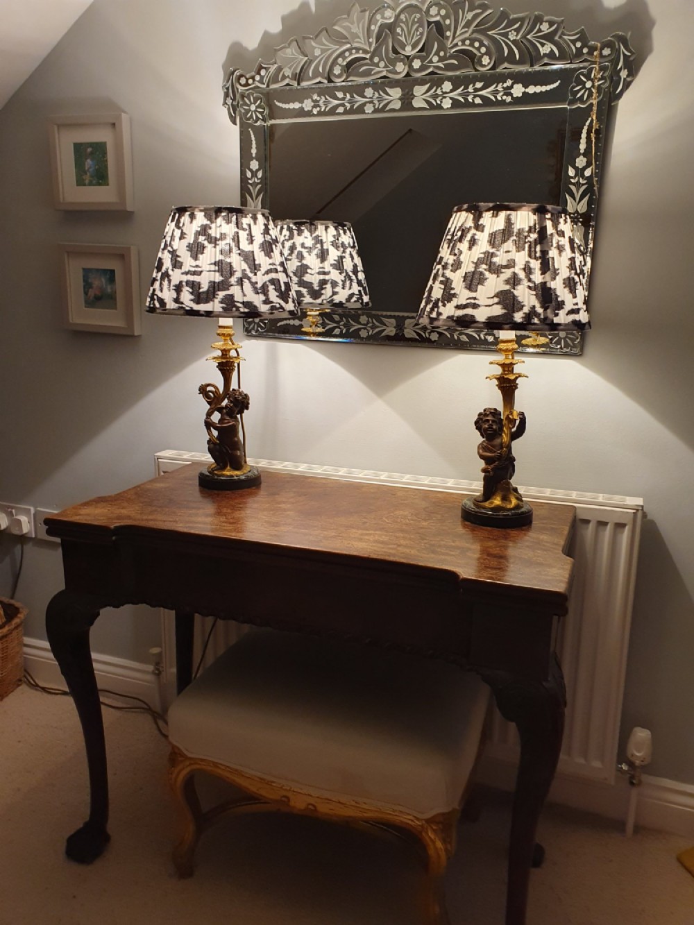 A pair of 1920s French-style dark bronze cherub table lamps with gilt foliate stems set on round black marble bases. View VI