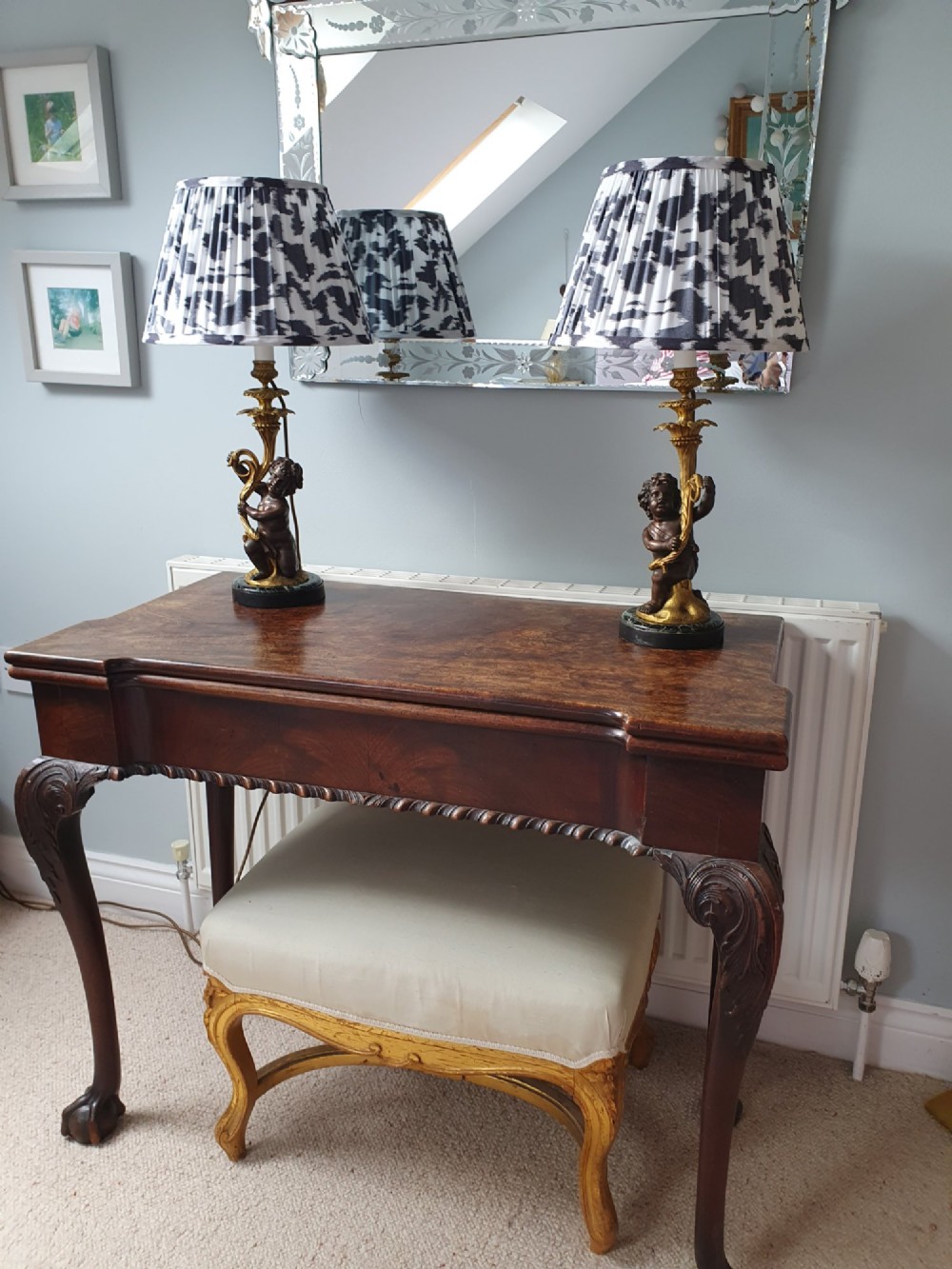 A pair of 1920s French-style dark bronze cherub table lamps with gilt foliate stems set on round black marble bases. View IX