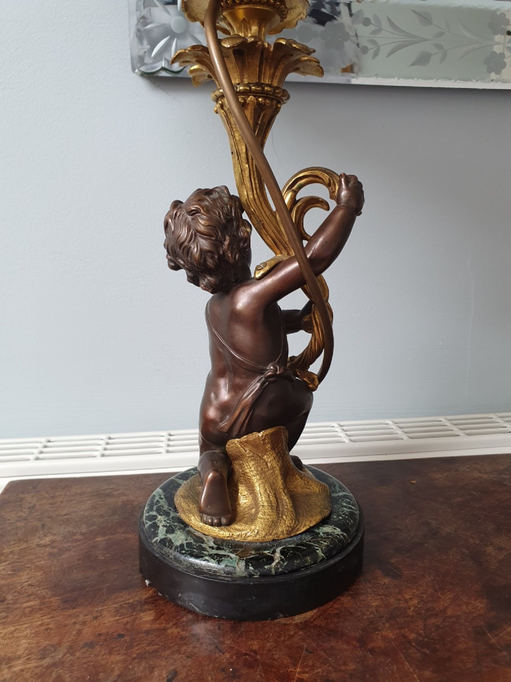 A pair of 1920s French-style dark bronze cherub table lamps with gilt foliate stems set on round black marble bases. View XII