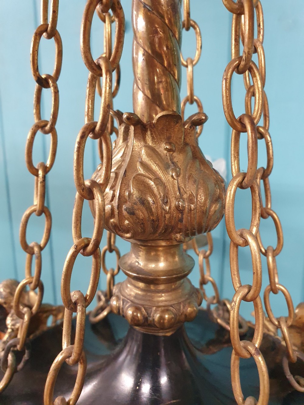 A French ebonised and brass three-arm chandelier featuring twisted metal arms, supporting chain suspension, and frosted glass shades shaped like open flowers. View II