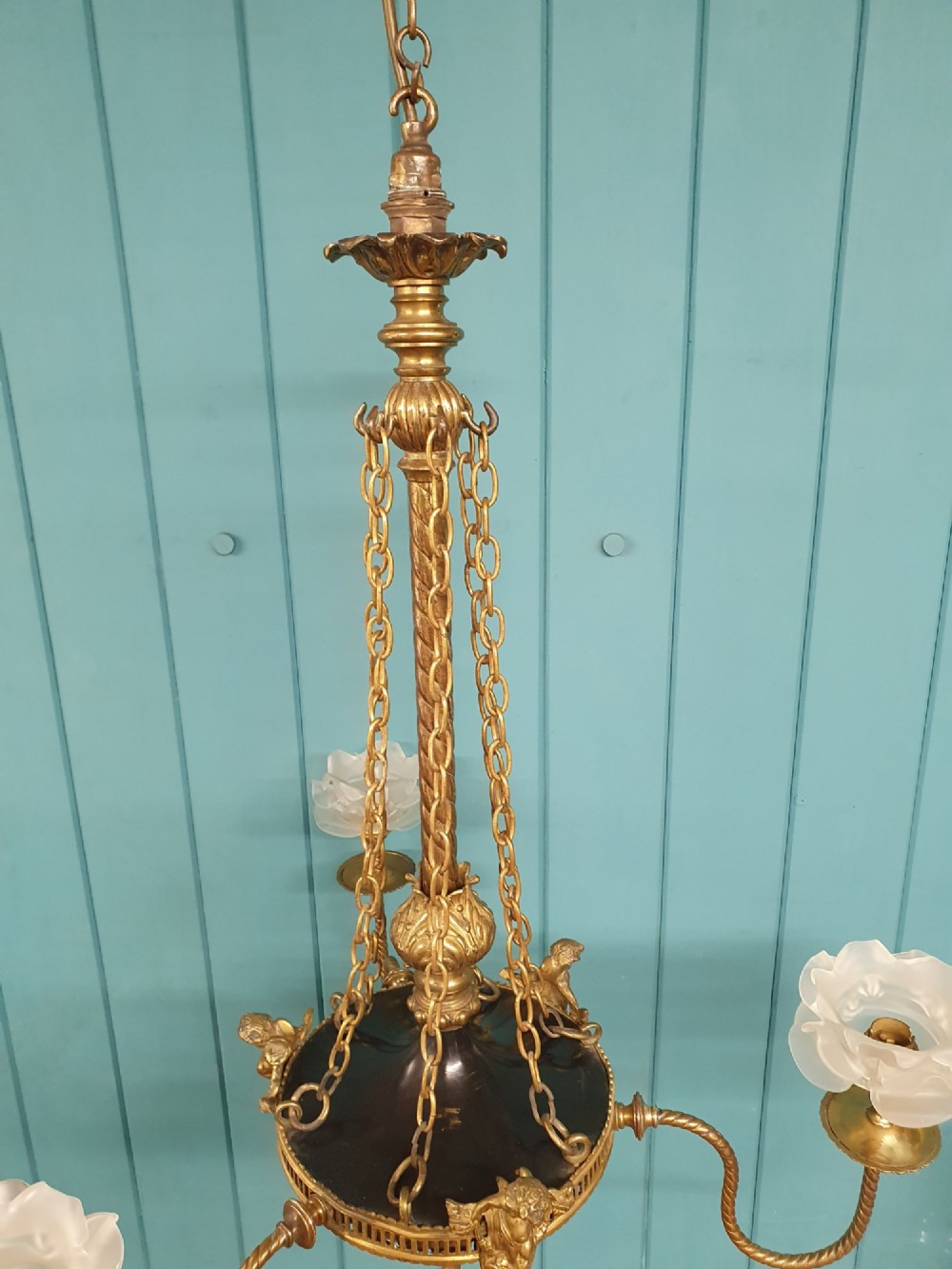 A French ebonised and brass three-arm chandelier featuring twisted metal arms, supporting chain suspension, and frosted glass shades shaped like open flowers. View VIII