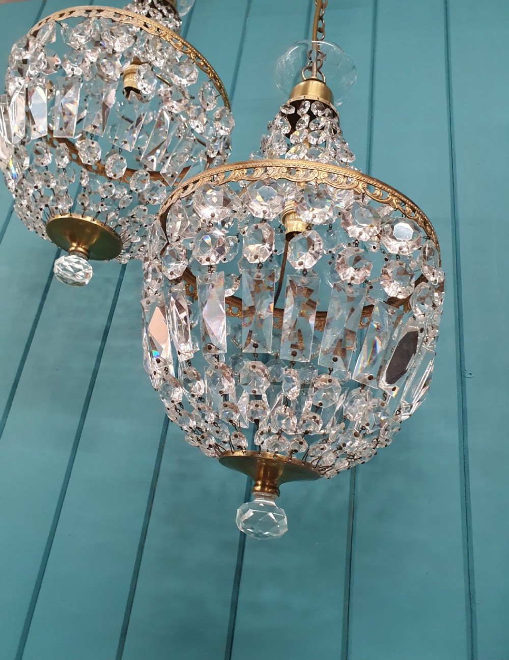 A pair of early 20th-century tent-style chandeliers featuring tier upon tier of faceted cut glass crystal beads and brass fittings. View II