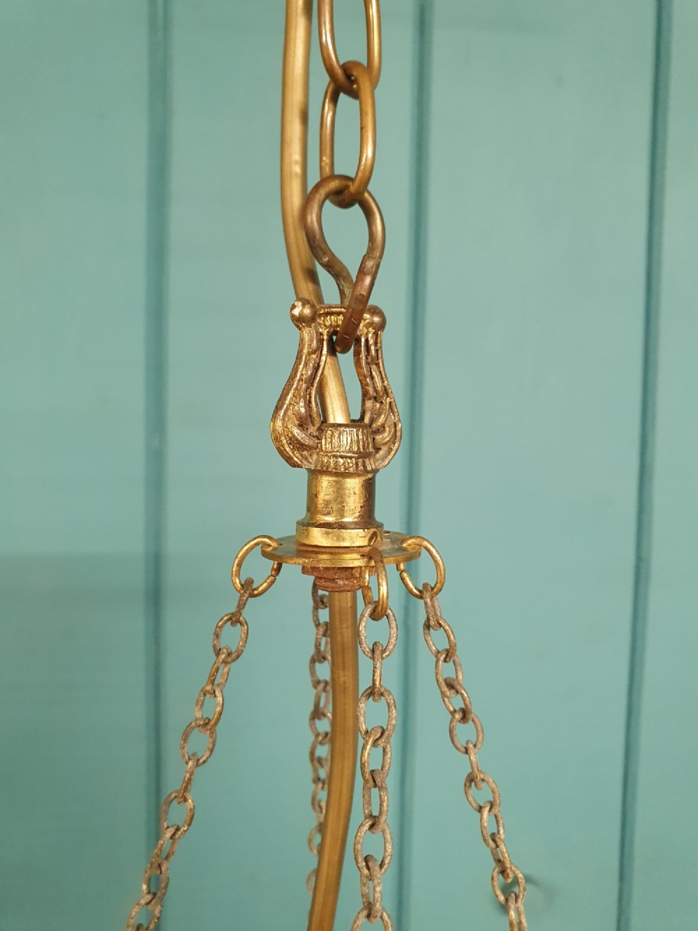A small early 20th-century pendant chandelier featuring tiered cut-glass crystal spikes suspended from a brass circular frame and hanging chain. View VII