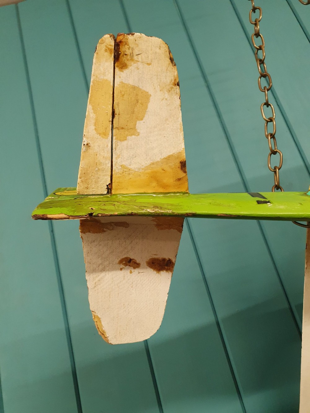 A mid-century hand-painted balsa wood control-line model aeroplane finished in green and cream with number seven painted on the fuselage. View III