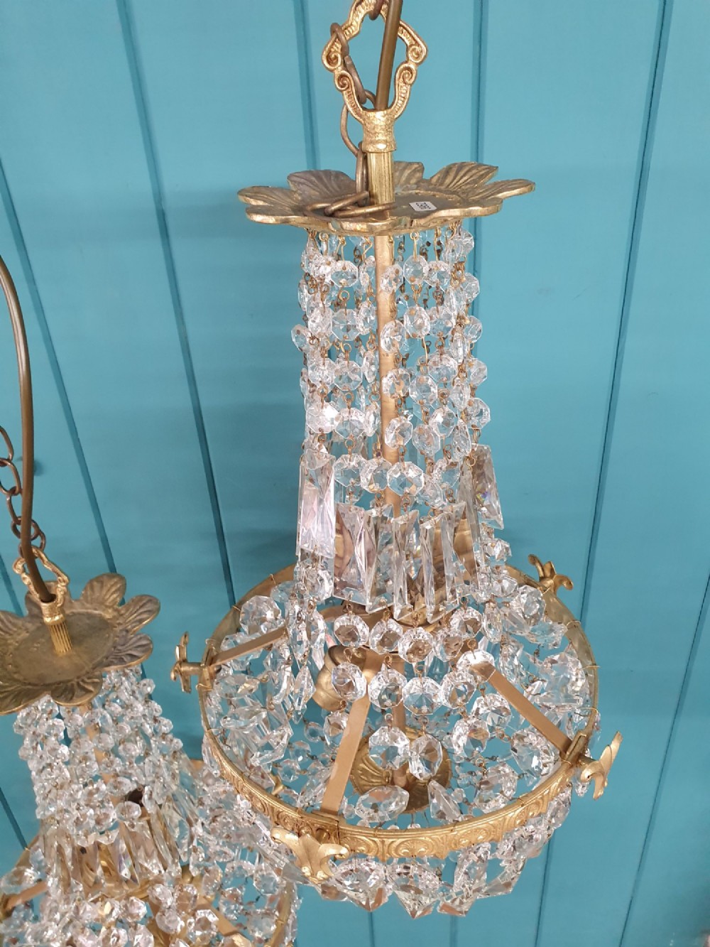 A pair of early 20th-century cut glass and brass tent chandeliers featuring tapered crystal bead strands and a lower band of rectangular faceted prisms. View II