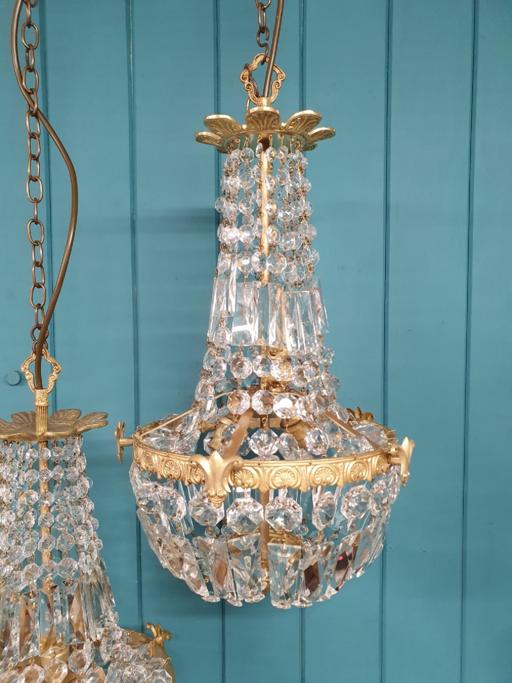 A pair of early 20th-century cut glass and brass tent chandeliers featuring tapered crystal bead strands and a lower band of rectangular faceted prisms. View V