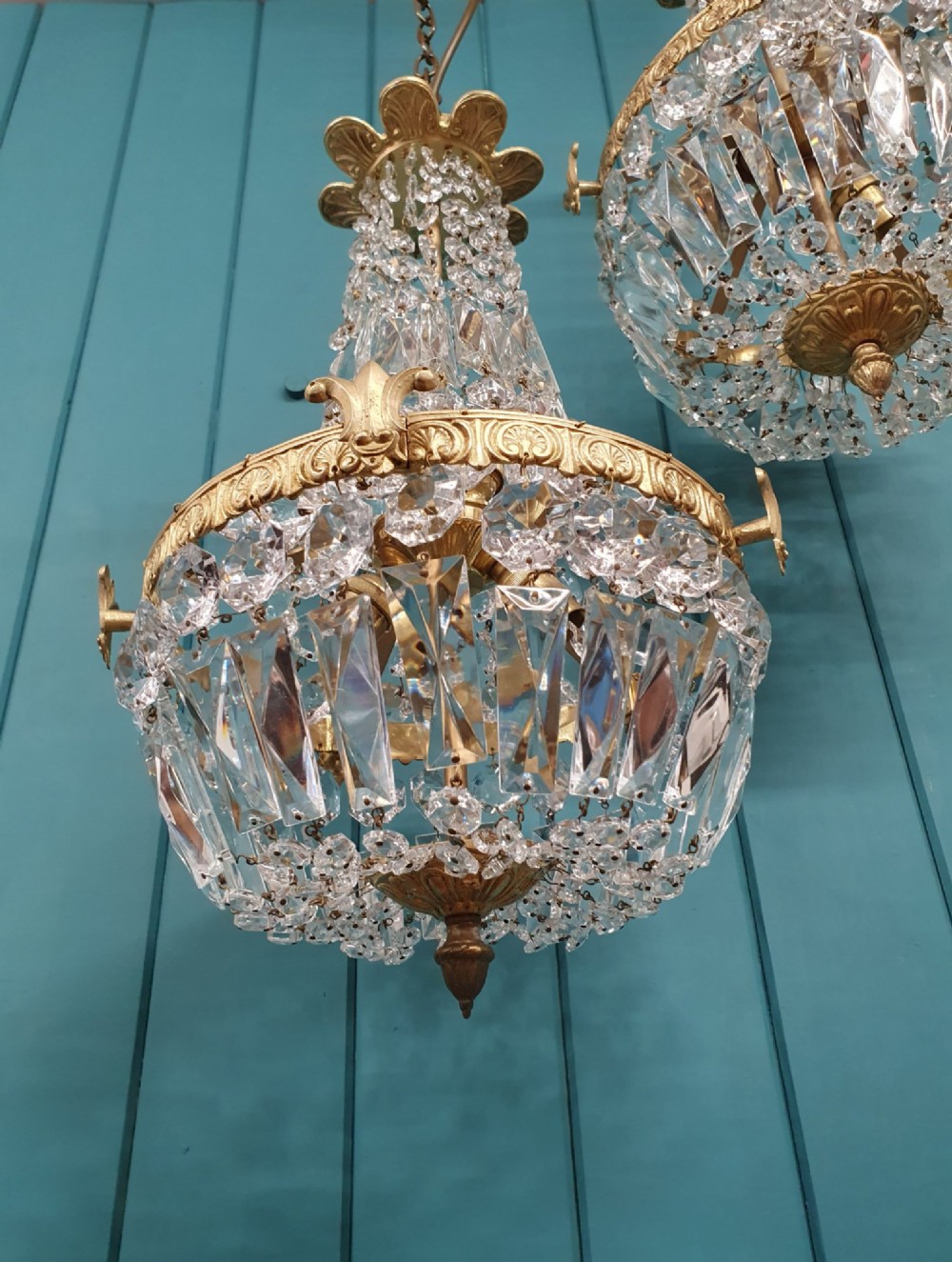A pair of early 20th-century cut glass and brass tent chandeliers featuring tapered crystal bead strands and a lower band of rectangular faceted prisms. View VI