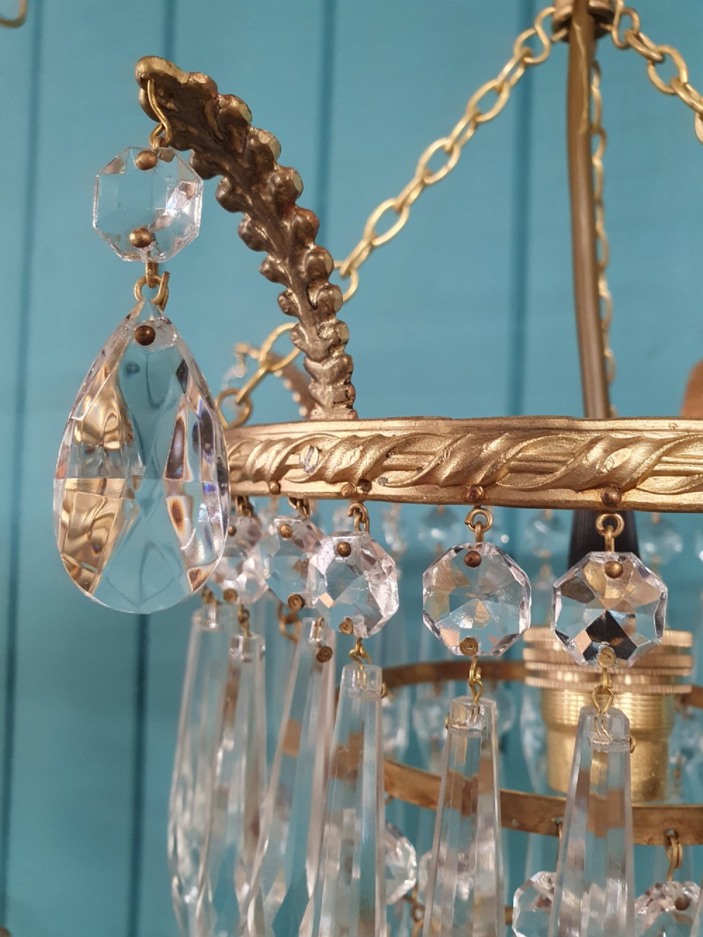 A pair of early 20th-century brass ceiling pendant chandeliers featuring tiered cut crystal spikes and hanging drops. View III