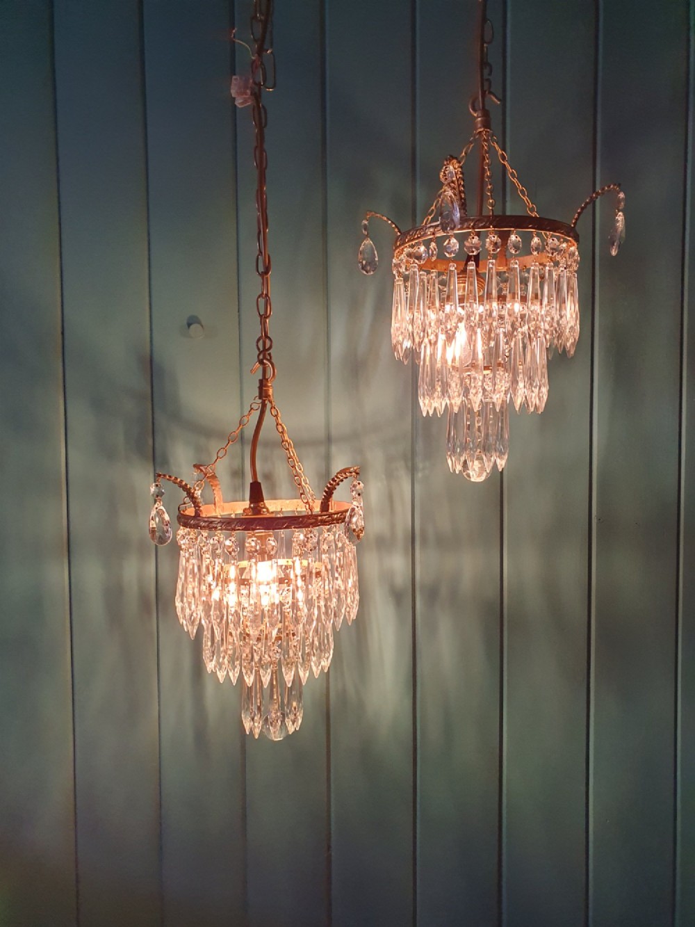 A pair of early 20th-century brass ceiling pendant chandeliers featuring tiered cut crystal spikes and hanging drops. View IV