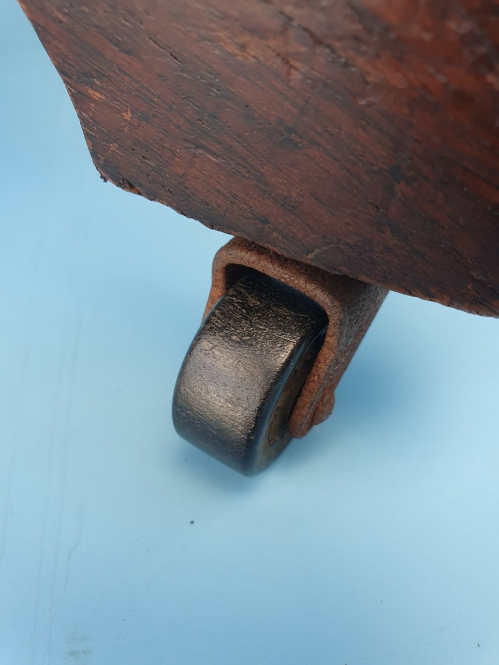 An Edwardian dark wood swivel desk chair with a slatted backrest, curved armrests, a brown leather padded seat, and four splayed legs on castors. View II