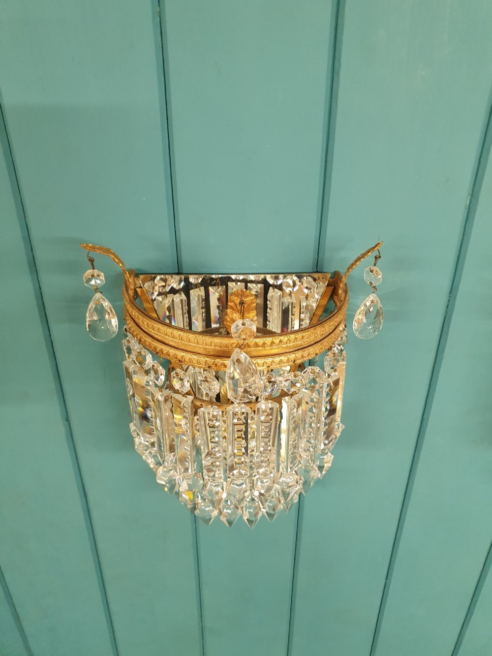 A pair of antique gilt brass wall lights with cascading tiers of cut glass crystal prisms. View II