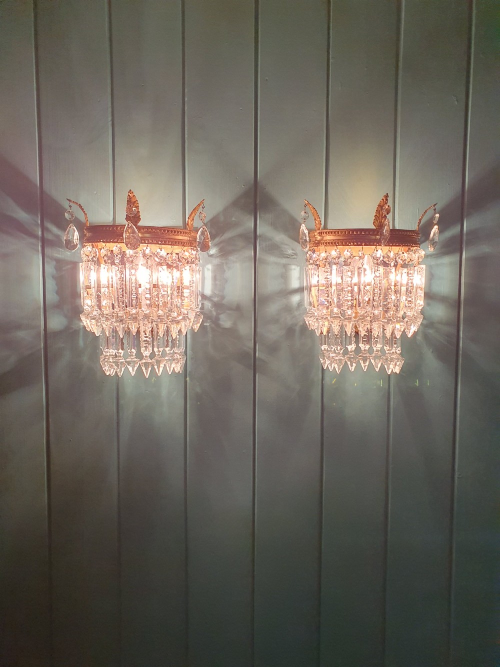 A pair of antique gilt brass wall lights with cascading tiers of cut glass crystal prisms. View VI
