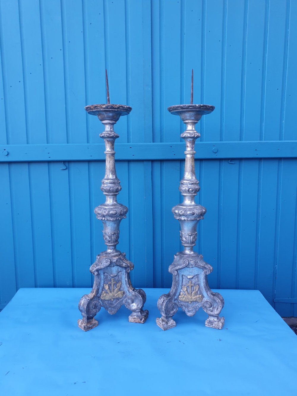 Pair of tall 18th-century Rococo gilt-silver pricket candlesticks with carved baluster shafts and scrolled triangular bases.