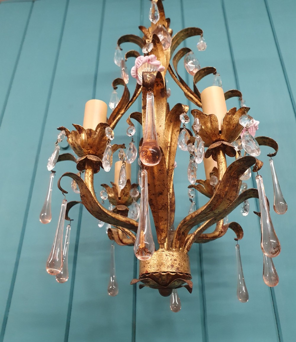 An early 20th-century French gilt metal three-arm chandelier adorned with clear crystal drops and pink glass flower accents. View II