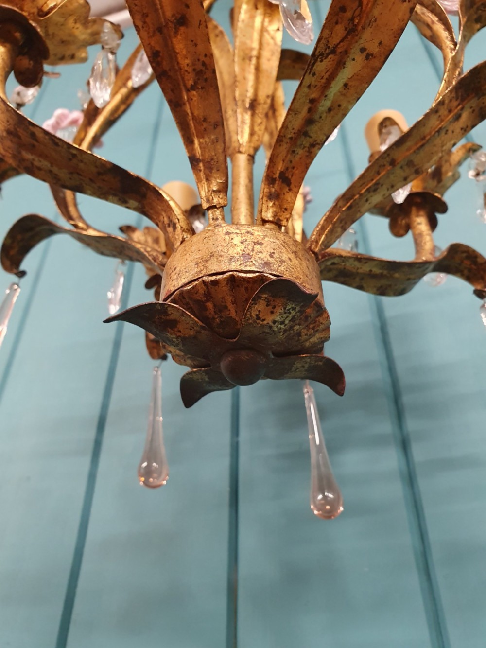 An early 20th-century French gilt metal three-arm chandelier adorned with clear crystal drops and pink glass flower accents. View III