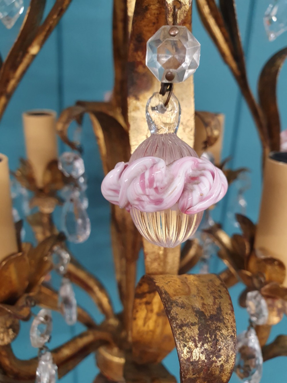 An early 20th-century French gilt metal three-arm chandelier adorned with clear crystal drops and pink glass flower accents. View IV
