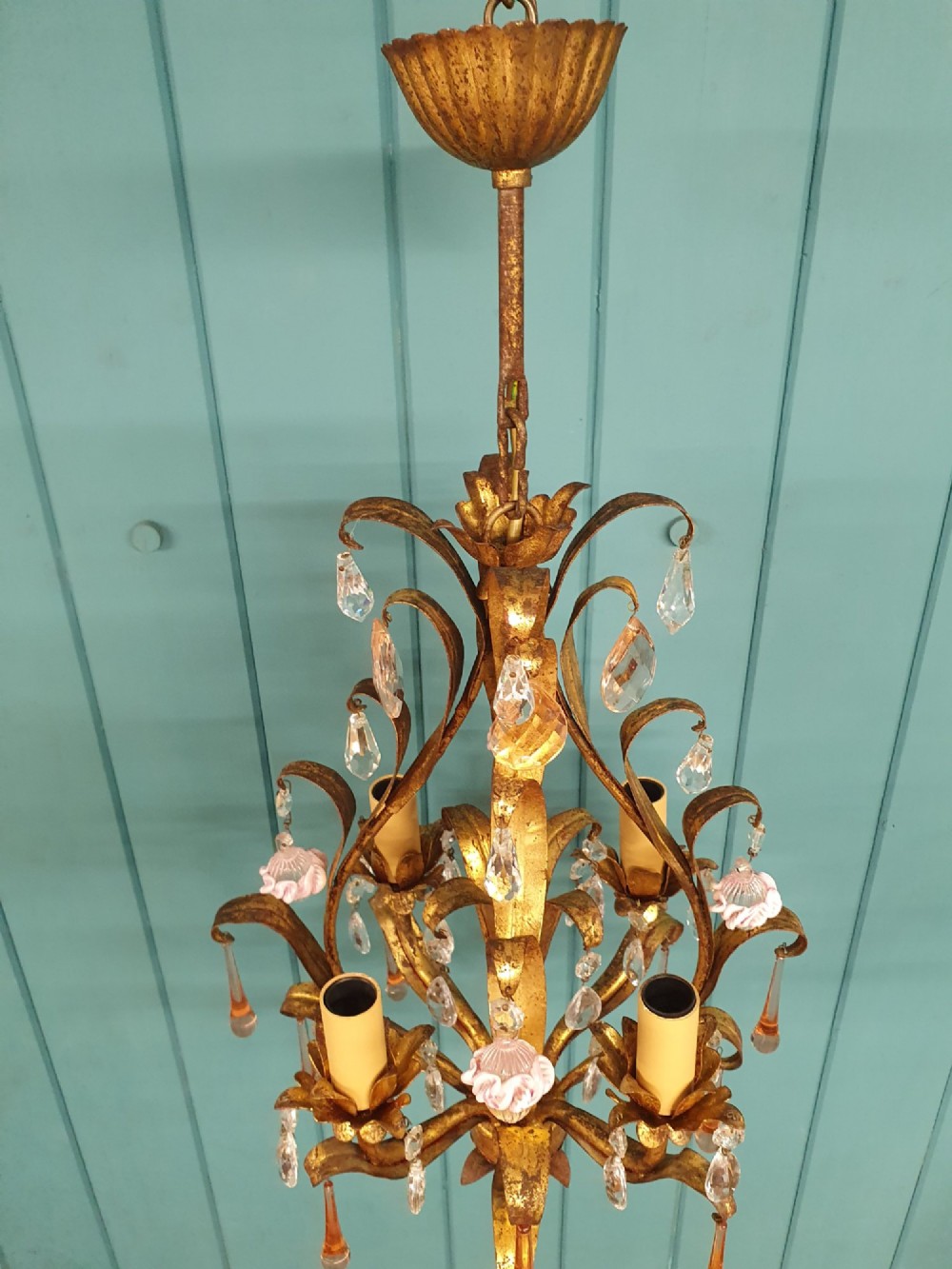 An early 20th-century French gilt metal three-arm chandelier adorned with clear crystal drops and pink glass flower accents. View VI