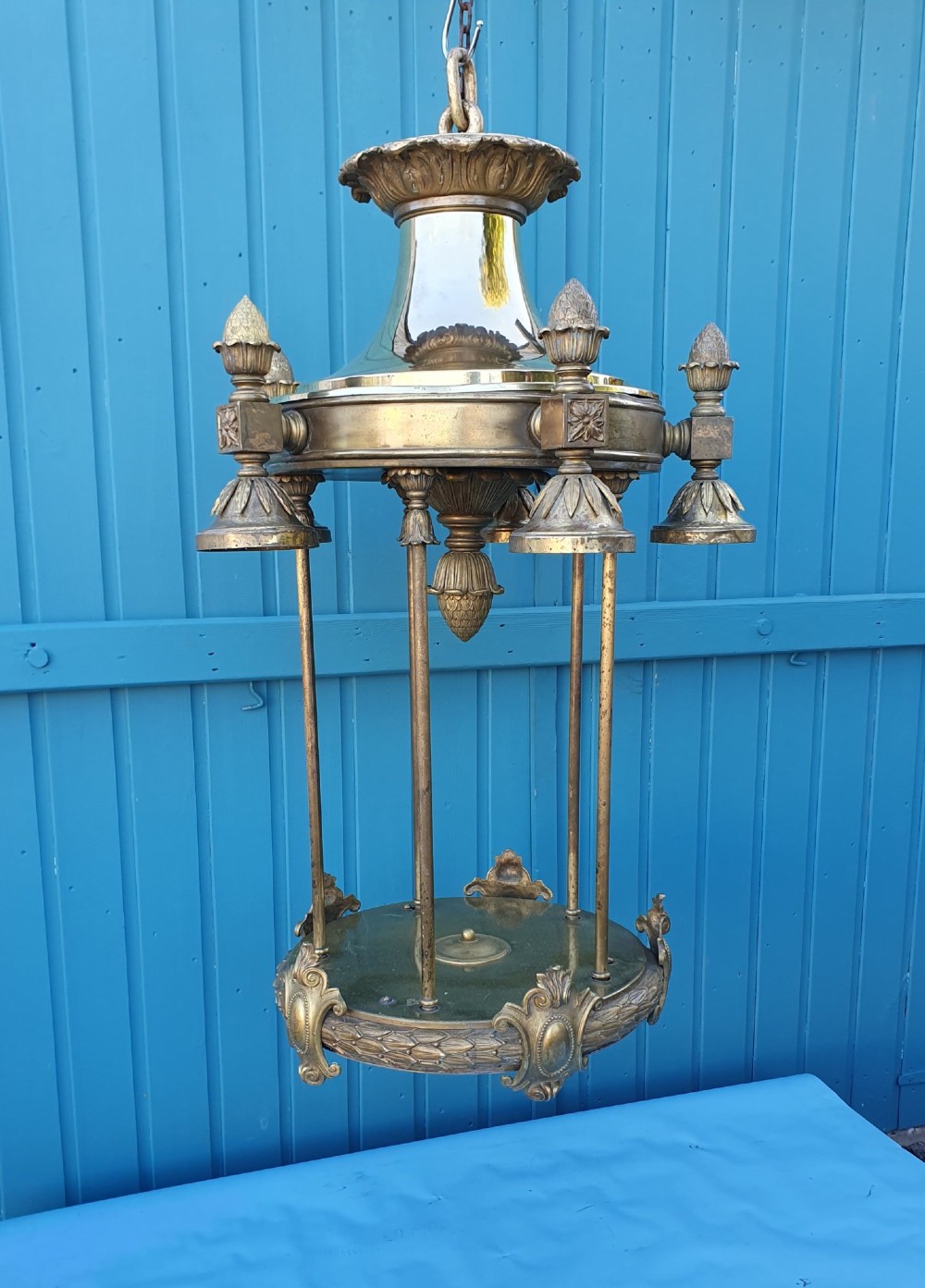 A pair of large early 20th-century brass hall lanterns featuring open columnar frames, acanthus leaf embellishments, decorative lower bands, and top hanging loops. View III