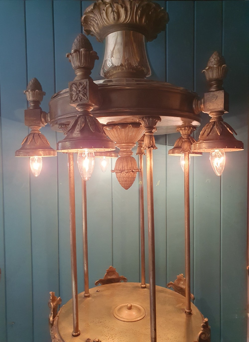 A pair of large early 20th-century brass hall lanterns featuring open columnar frames, acanthus leaf embellishments, decorative lower bands, and top hanging loops. View IV