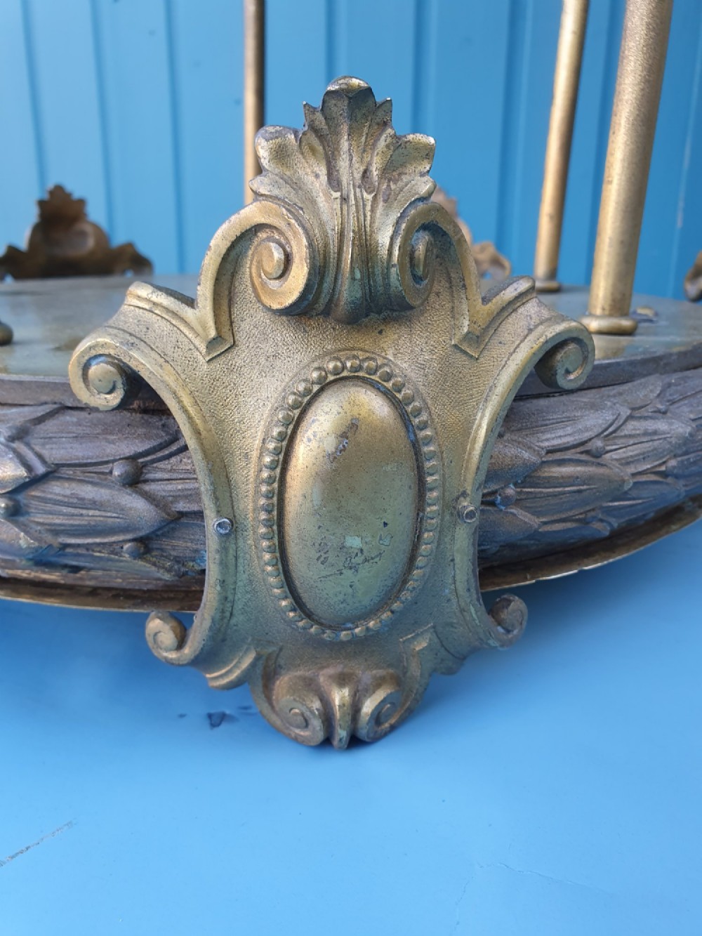 A pair of large early 20th-century brass hall lanterns featuring open columnar frames, acanthus leaf embellishments, decorative lower bands, and top hanging loops. View V
