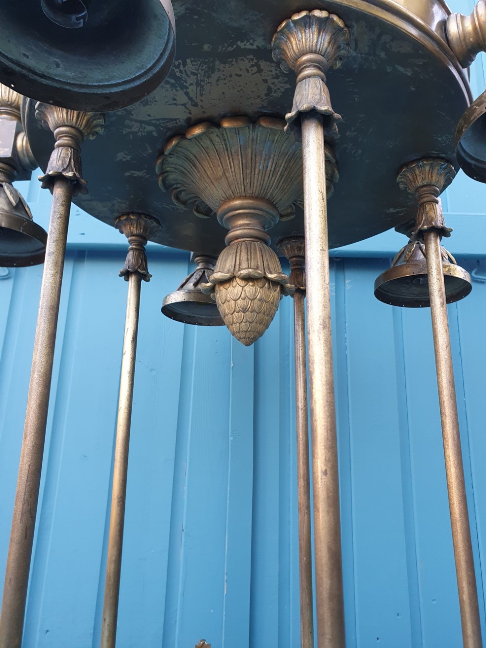 A pair of large early 20th-century brass hall lanterns featuring open columnar frames, acanthus leaf embellishments, decorative lower bands, and top hanging loops. View VI