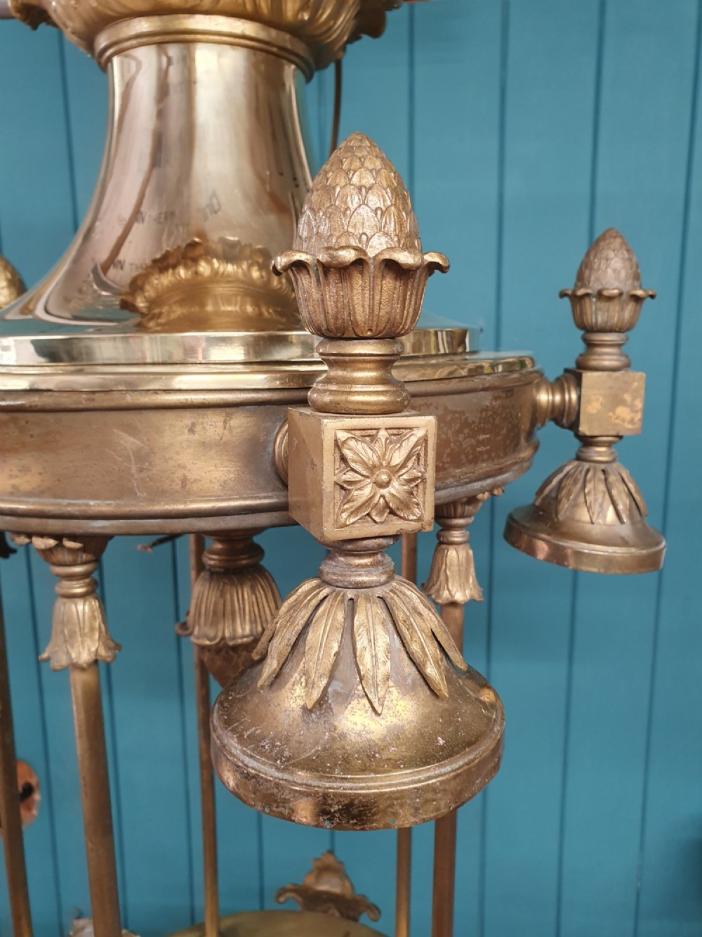 A pair of large early 20th-century brass hall lanterns featuring open columnar frames, acanthus leaf embellishments, decorative lower bands, and top hanging loops. View VIII