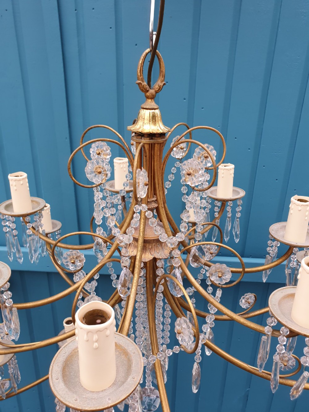 A pair of brass two-tier fourteen-arm chandeliers adorned with cut glass crystal droplets and faux candle light sockets. View VI