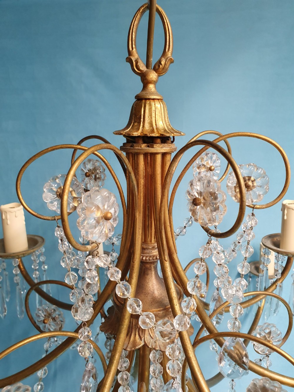 A pair of brass two-tier fourteen-arm chandeliers adorned with cut glass crystal droplets and faux candle light sockets. View XI