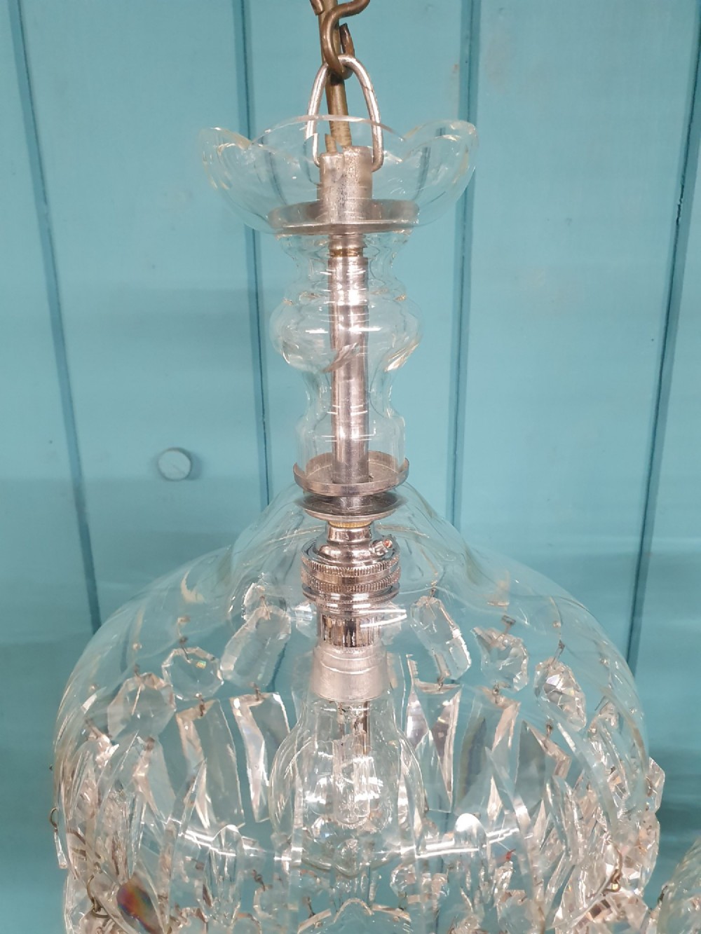 A pair of early 20th-century crystal bag pendant lights featuring dome glass tops and cascading cut glass drops hanging from brass chains. View V