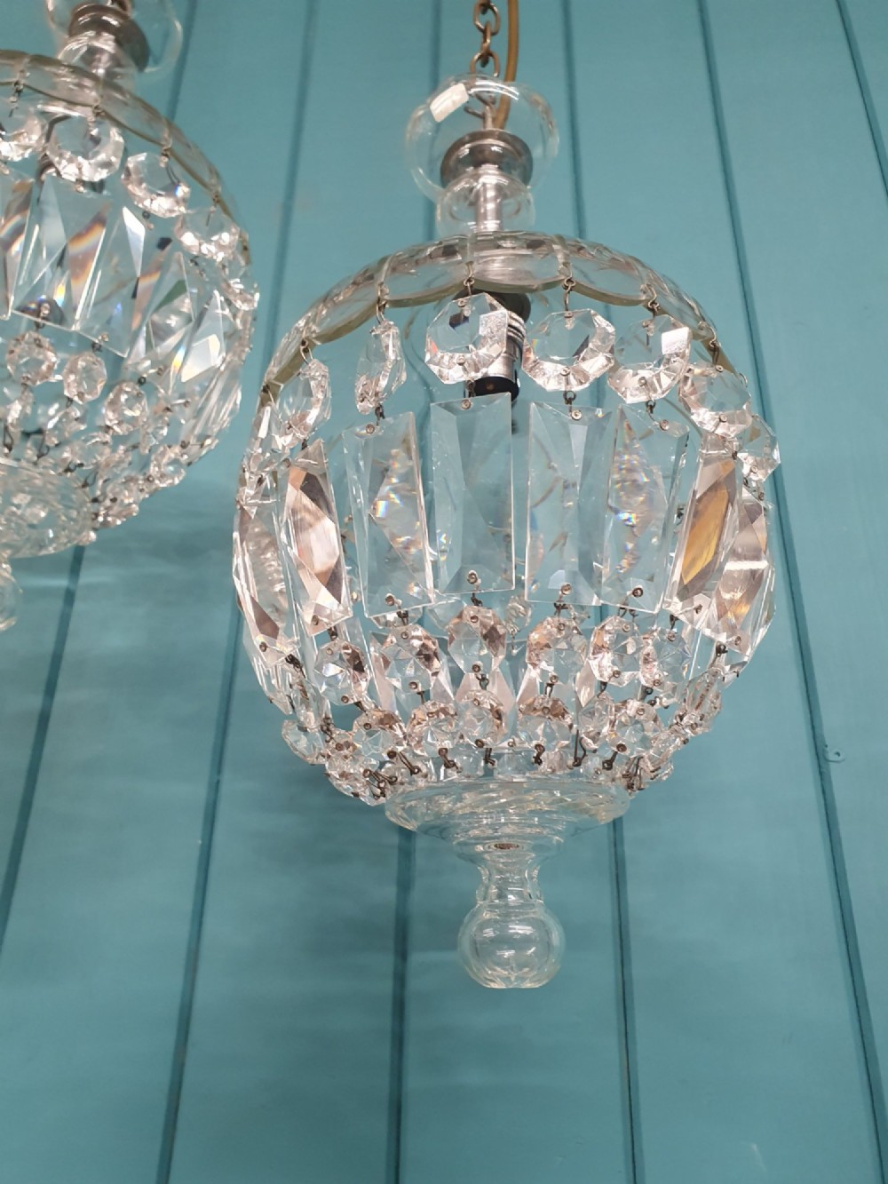 A pair of early 20th-century crystal bag pendant lights featuring dome glass tops and cascading cut glass drops hanging from brass chains. View VII