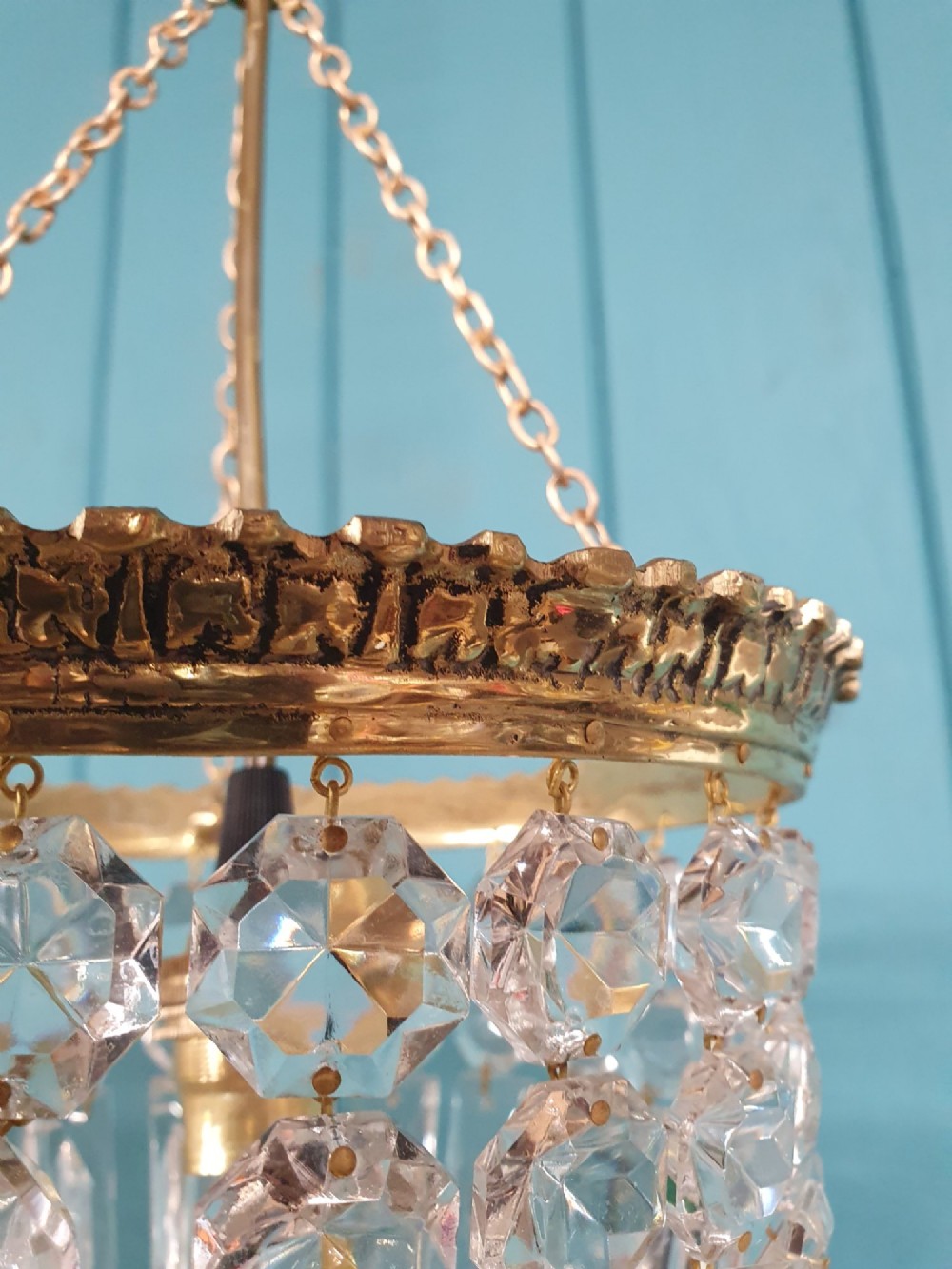 An early twentieth-century gilt brass basket chandelier suspended by chains with tiered cut glass prisms. View VIII